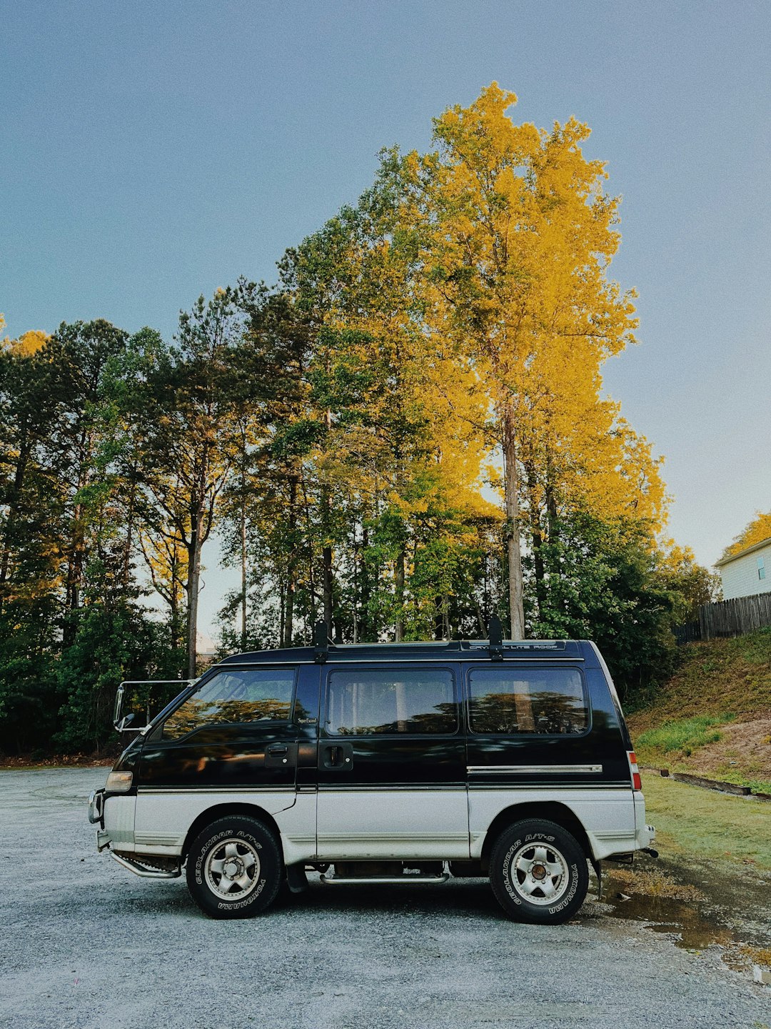 a-black-and-white-van-parked-in-a-parking-lot-qlccc2ecpns