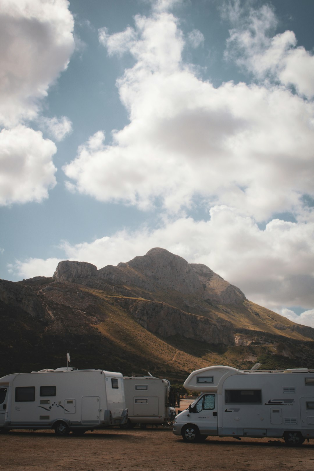 about-img-01 a-couple-of-trucks-parked-next-to-a-mountain-bdcjybwep6u